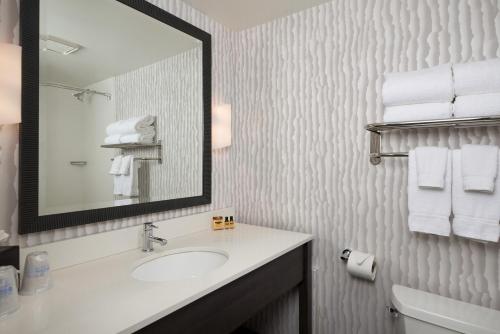 a bathroom with a sink and a mirror and towels at Best Western Plus Agate Beach Inn in Newport