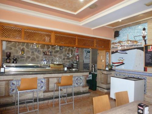 a restaurant with a bar with orange chairs at Hostal Cortés in Garrucha