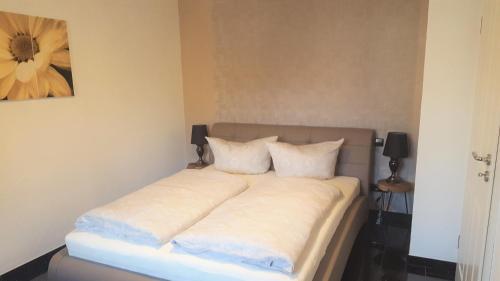 a bed with white sheets and pillows in a bedroom at Rust-Fewo-Hotel in Rust