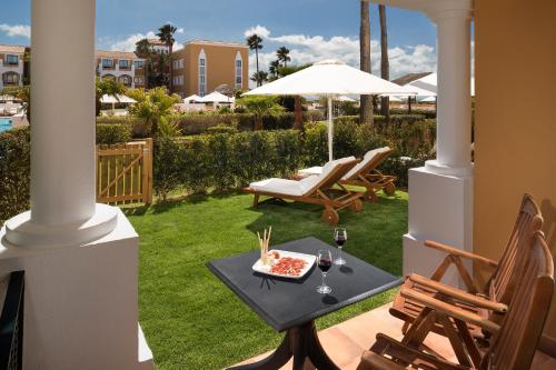 a patio with a table and chairs and an umbrella at Palacio de Sancti Petri, a Gran Meliá - The Leading Hotels of the World in Chiclana de la Frontera