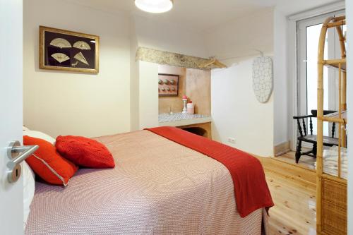 a bedroom with a bed with red pillows and a ladder at FeelingLisbon Tejo in Lisbon