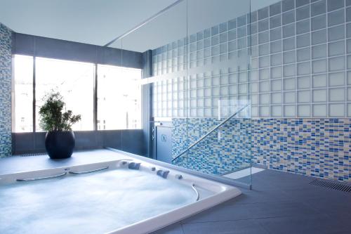 uma casa de banho com uma banheira com um vaso de plantas em Clarion Congress Hotel Prague em Praga