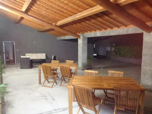 a patio with wooden tables and chairs under a wooden ceiling at LAGOON'S HOUSE in Sete Cidades