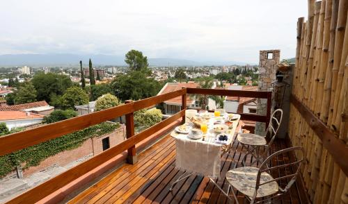 a table on a balcony with a view of a city at Kkala Boutique Hotel in Salta