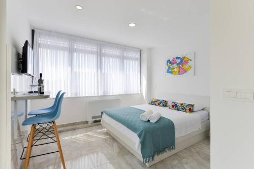 um quarto branco com uma cama e uma cadeira azul em Ivy Apartments em Zadar