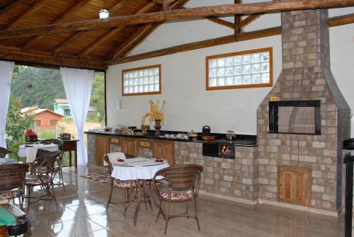 a kitchen with a table and chairs in a room at Pousada Requinte Serrano in Urubici