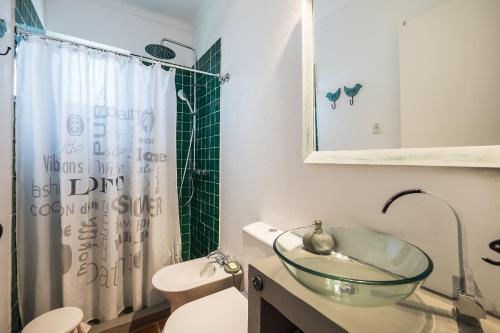 Un baño con lavabo de cristal y inodoro. en Monte do Medronhal, en Grândola
