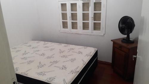 Casa para 12 pessoas في بيراتوبا: غرفة نوم صغيرة بها سرير ونافذة
