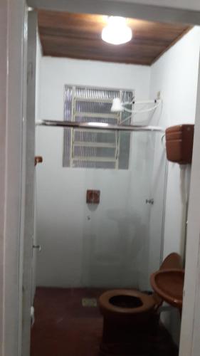 uma casa de banho com um WC e uma porta de vidro em Casa para 12 pessoas em Piratuba
