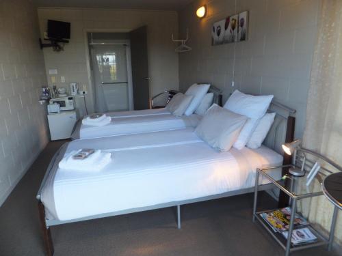 A bed or beds in a room at Waitomo Golfstays B&B