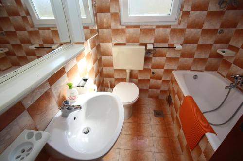 łazienka z umywalką, toaletą i wanną w obiekcie Apartment Michelle w Bibinje