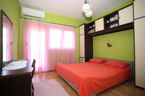 sypialnia z czerwonym łóżkiem i zielonymi ścianami w obiekcie Apartment Michelle w Bibinje