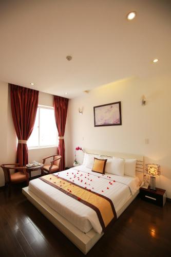 a bedroom with a large bed with red flowers on it at Lavender Hotel in Thu Dau Mot