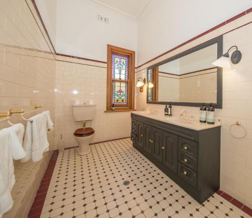 a bathroom with a sink and a toilet and a mirror at Barossa Valley View Guesthouse in Tanunda