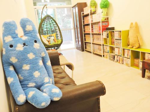 a blue teddy bear sitting on a chair in a library at Deer House in Yung-an-ts'un