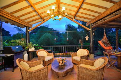 a patio with wicker chairs and a table at Finca Villa Gregory in Quimbaya