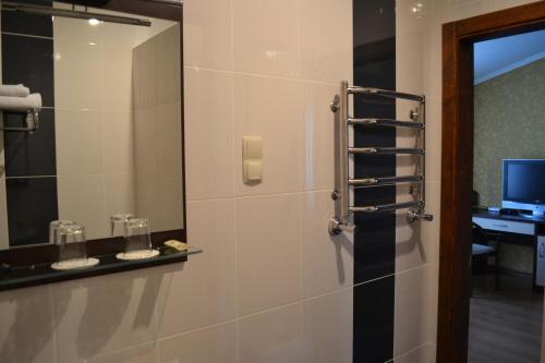卡爾可夫的住宿－帕洛瑪酒店，一间带镜子和淋浴的浴室以及一张书桌
