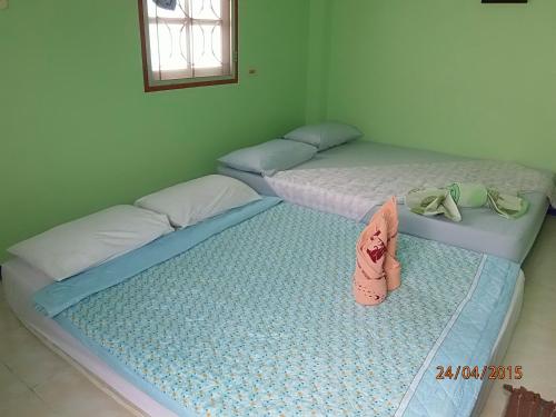 two twin beds in a room with one with a diaper at Dahla House Ranong in Ranong