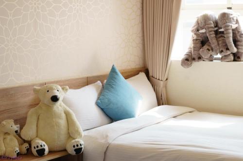 two teddy bears sitting on a bed in a bedroom at King Hot Spring Hotel in Jiaoxi
