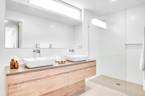 a bathroom with two sinks and a mirror at Headlands Austinmer Beach in Austinmer