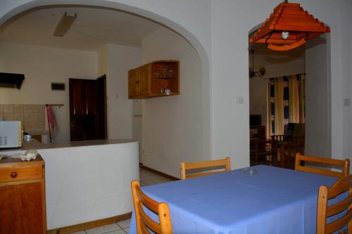 a kitchen with a table with a blue table cloth on it at Villas Pingouin in Blue Bay