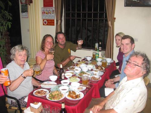 a group of people sitting around a table with food at Lys Homestay in Ninh Binh