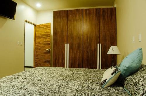 a bedroom with a bed and a wooden cabinet at El Refugio in Ensenada