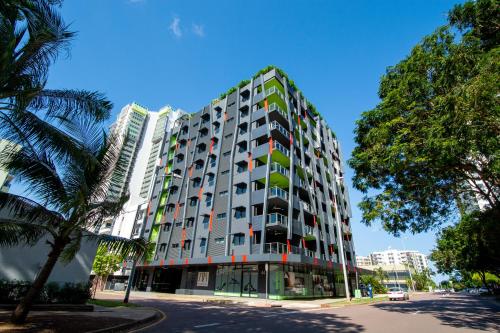 a tall building with trees in front of it at Magnum Serviced Apartments in Darwin
