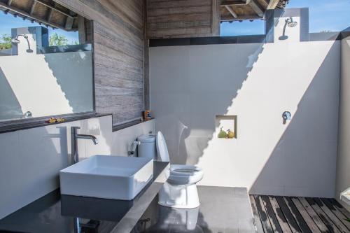 a bathroom with a sink and a toilet at Ombak Bay Lembongan in Nusa Lembongan