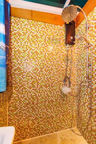 a shower in a bathroom with a tiled wall at Baan Ratchapruek in Phuket Town