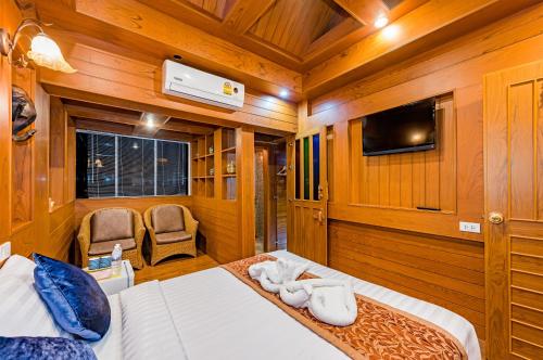 a bedroom with a bed and a tv in a room at Baan Ratchapruek in Phuket Town