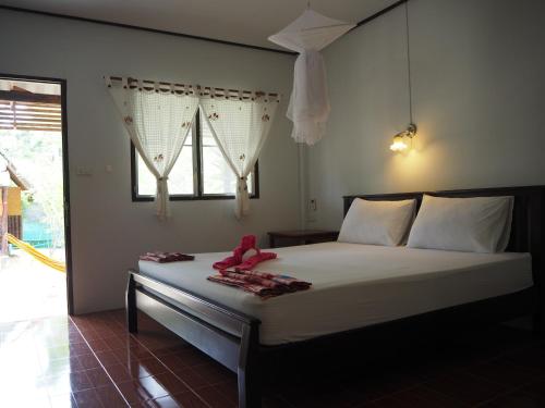 a bedroom with a bed with a teddy bear on it at Bluesky Beach Bungalows in Ko Lanta