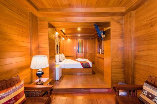 a bedroom with a bed in a room with wooden walls at Baan Ratchapruek in Phuket Town