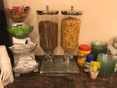 a counter with two tall vases filled with cereal at Hotel Adsubia in Denia