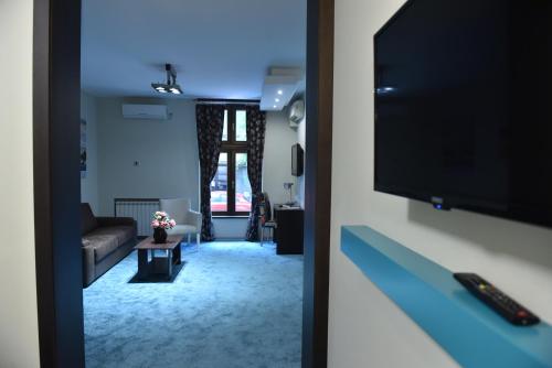 un soggiorno con TV e divano di City Code In Joy a Belgrado
