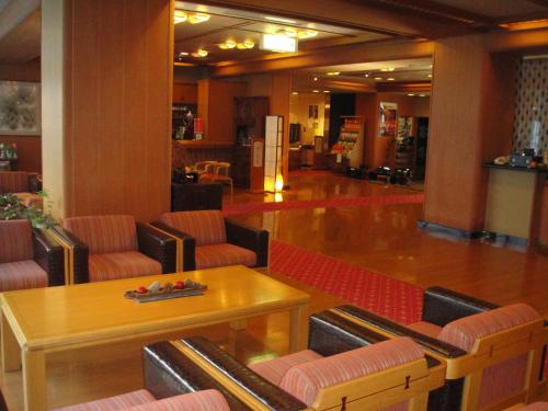 a lobby with chairs and a table in a building at Ryokan Sakaya in Nozawa Onsen