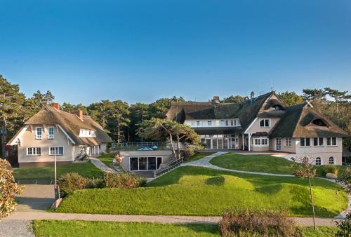 a large white house with a green lawn at Strandhaus Ahrenshoop in Ahrenshoop