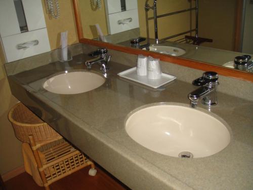 a bathroom counter with two sinks and a mirror at Ryokan Sakaya in Nozawa Onsen