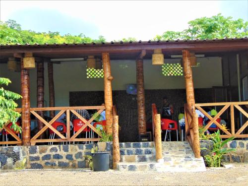 a porch of a house with a person sitting at a table at Residêncial Tamarindos in M. Peixe