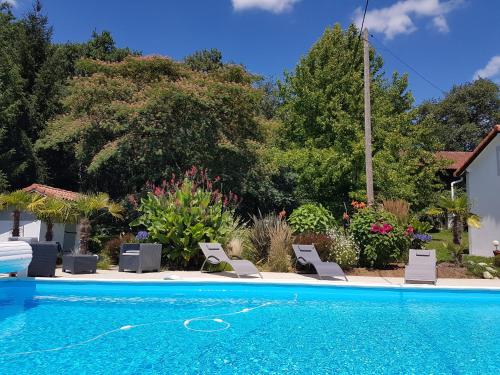 uma piscina com cadeiras e uma casa em Gîte Pigerot em Lucbardez-et-Bargues