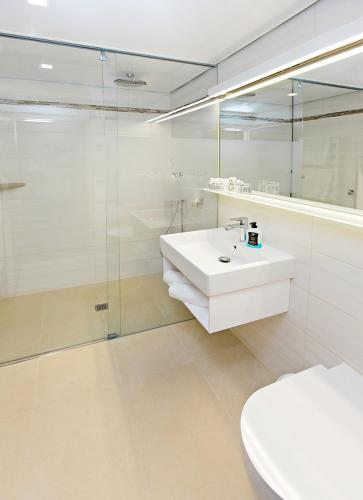 a white bathroom with a sink and a shower at AKZENT Hotel Restaurant Altdorfer Hof in Weingarten