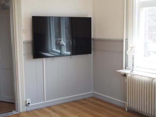 a flat screen tv on the corner of a wall at Orsastuguthyrning-Kyrkbyn in Orsa
