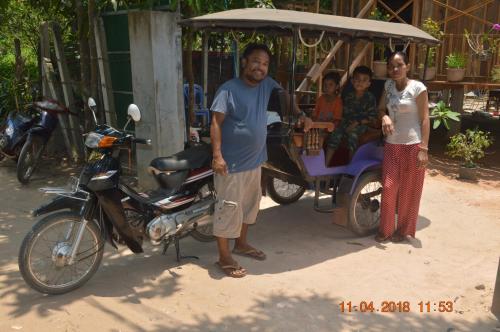 a group of people standing next to a motorcycle and a man at Sok Phen Homestay in Siem Reap