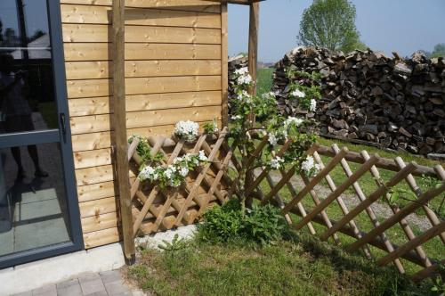 a fence with flowers on it next to a building at Gîte l'Atelier in Lecelles