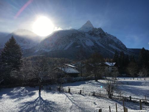 a snow covered mountain with the sun in the background at Landhaus Holzereck in Ehrwald