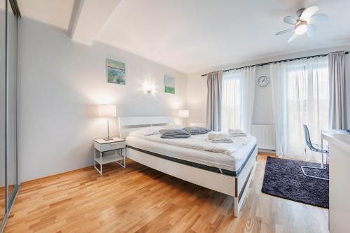 um quarto branco com uma cama e uma janela em Apartamenty Sun & Snow Villa Klif em Jastrzebia Gora