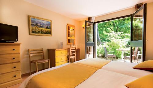 Un pat sau paturi într-o cameră la Club Vacances Bleues Domaine de Château Laval