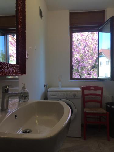 a bathroom with a tub and a washing machine at Guesthouse Marko in Bled