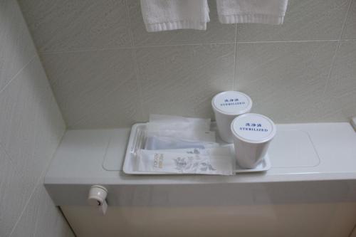 a bathroom counter with two cups on top of it at Hotel Southern Coast Miyakojima in Miyako-jima