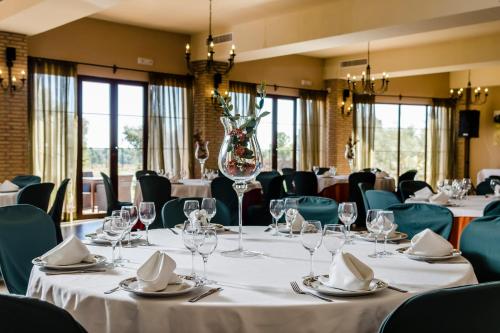 a conference room with tables and chairs and glasses at Hotel Rural Los Nogales in Pozo Alcón